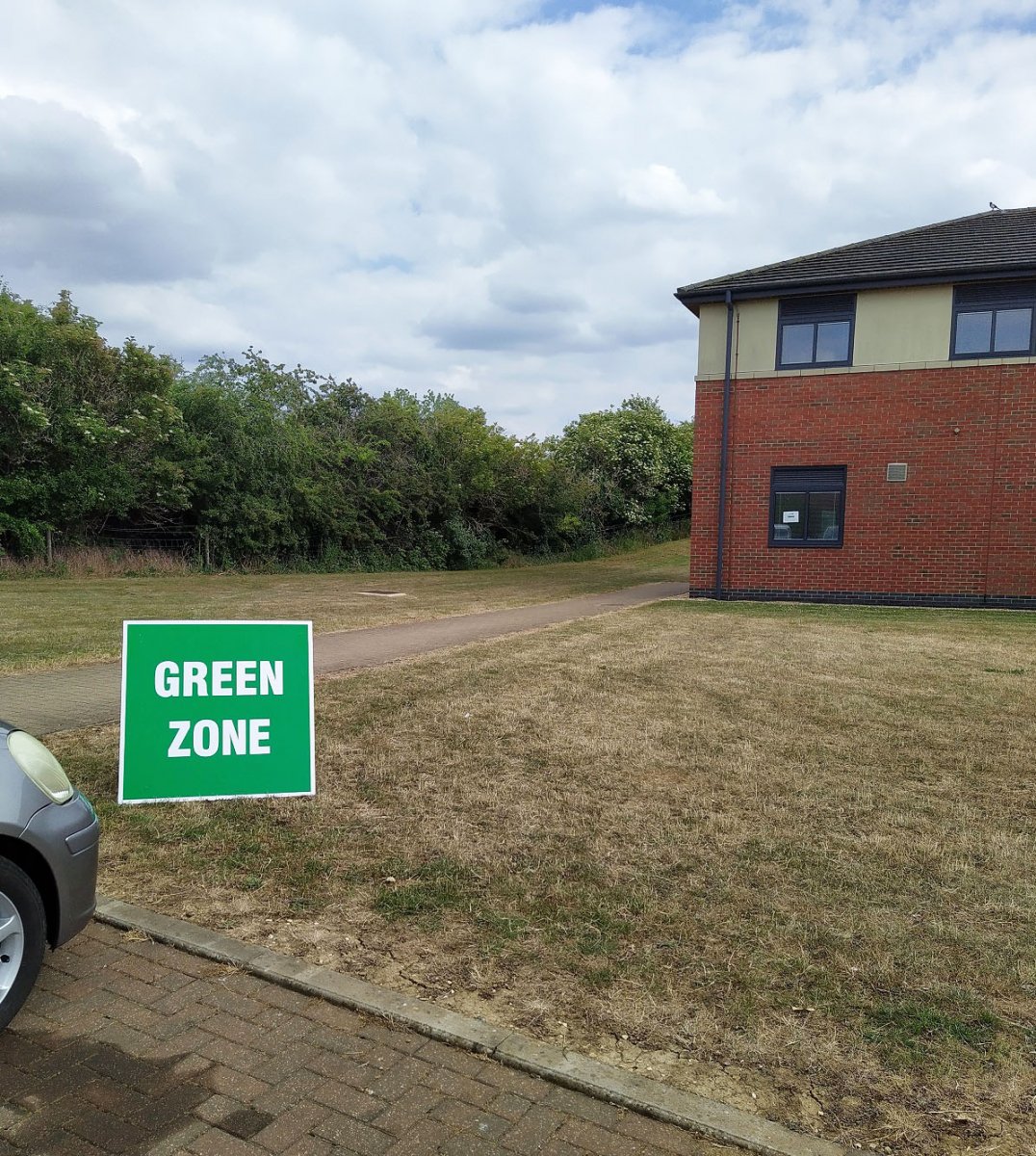 A sign saying 'green zone' in the car park of a GP surgery.