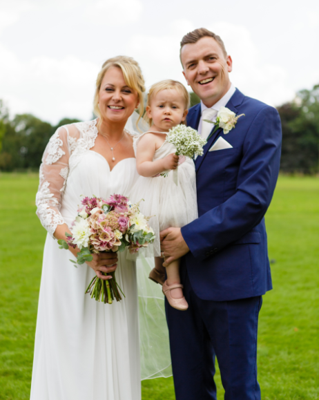 Hannah, her husband & Lily at their wedding